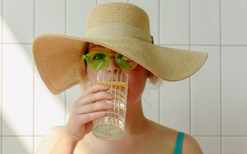 Frau mit Hut trinkt Wasser Frau mit Hut trinkt Wasser